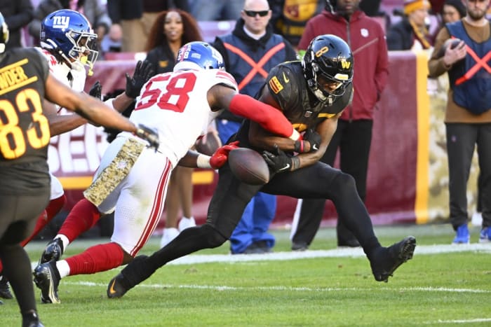 Nov 19, 2023; New York Giants linebacker Bobby Okereke (58) strips the ball from Washington running back Brian Robinson Jr. (8). Mandatory Credit: Brad Mills-USA TODAY Sports